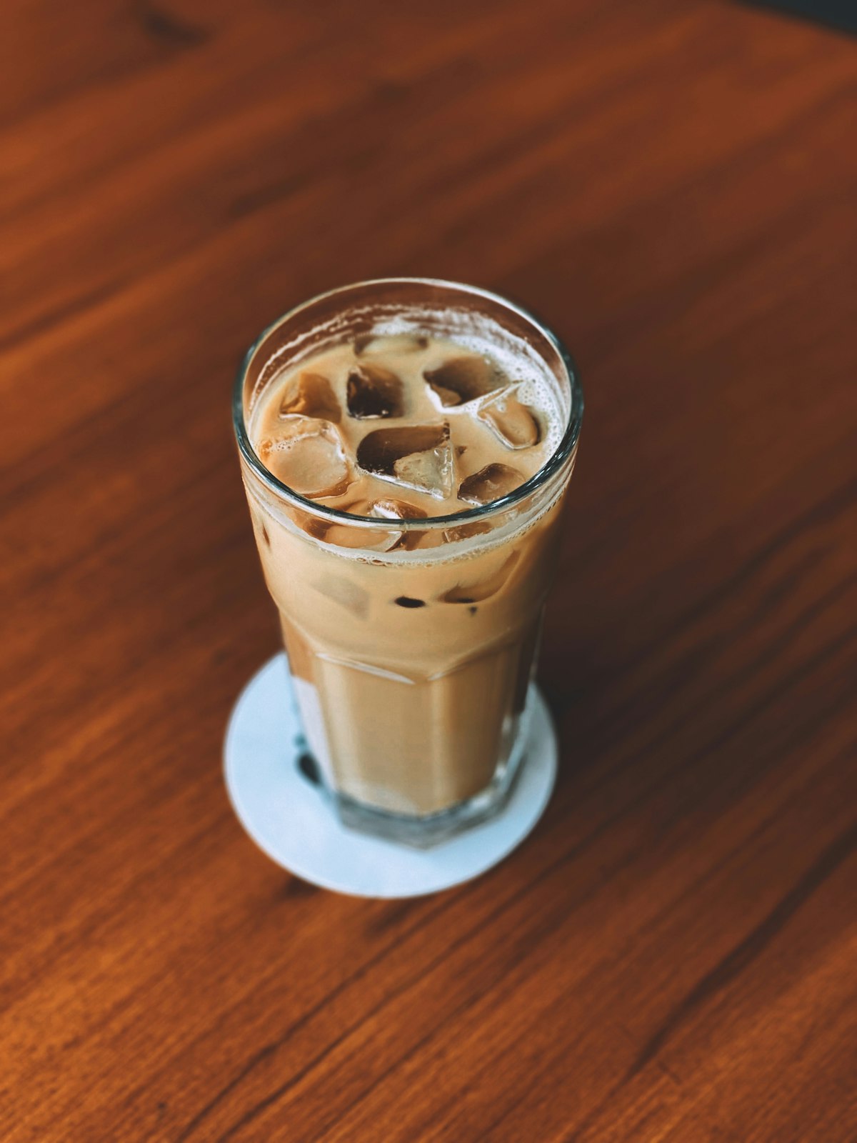 Iced latte in a clear glass on a wooden table