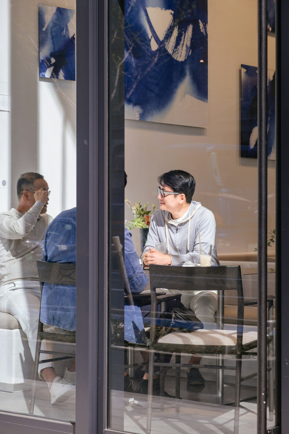 People talking inside a Tokyo cafe, seen through its window