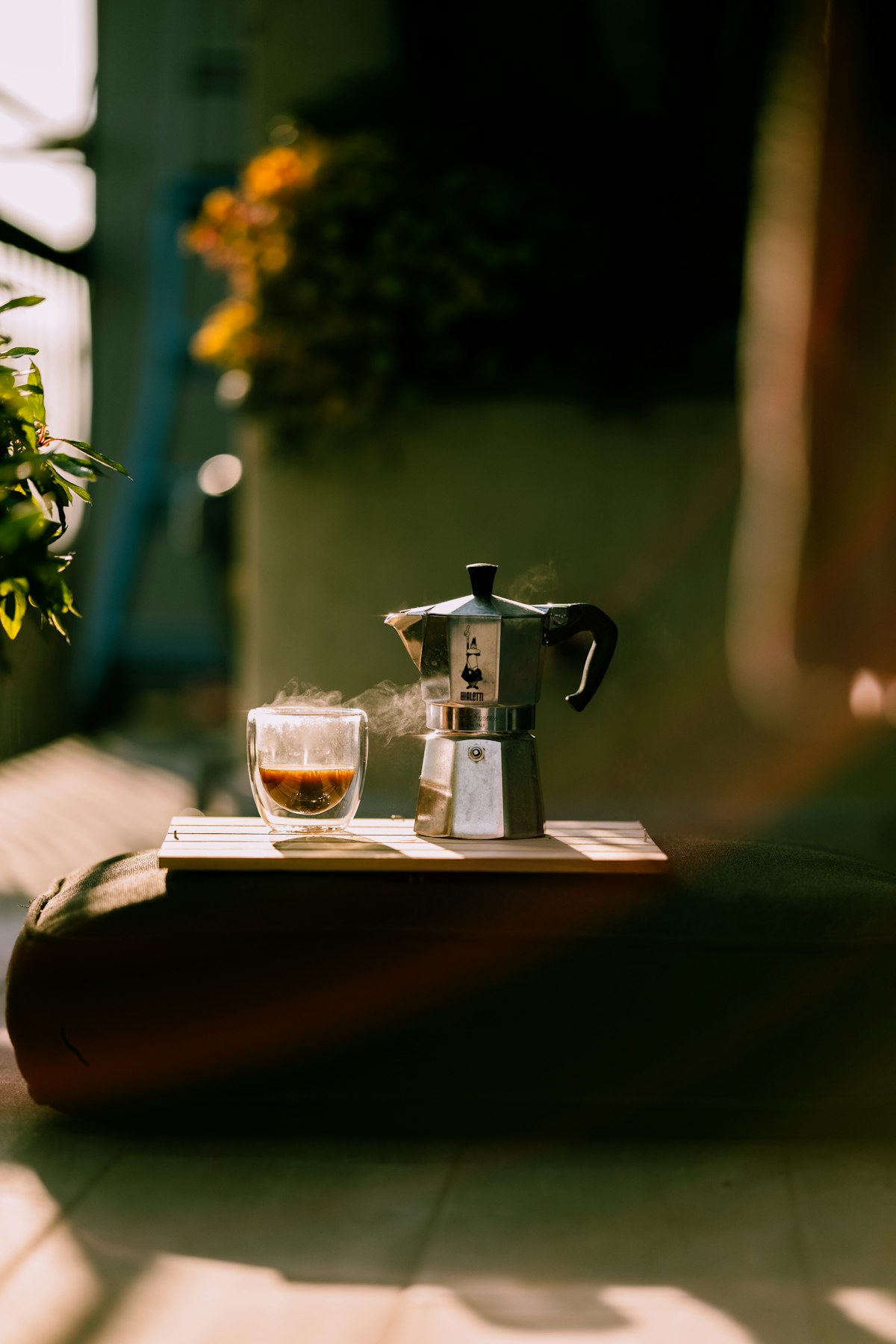 Moka pot and coffee on a sunlit outdoor table in Lombardy, Italy