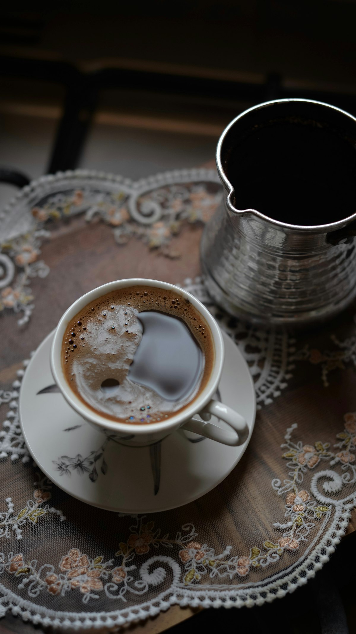 A cup of Turkish coffee and a cezve on a tray
